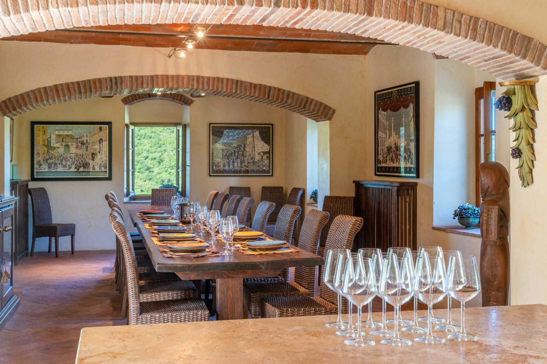 Long dining table set for twenty under brick-arched vaulted ceilings