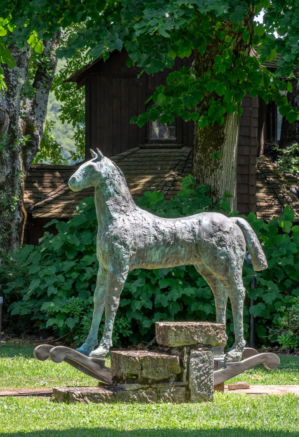 Bronze horse sculpture on a stone plinth in the garden