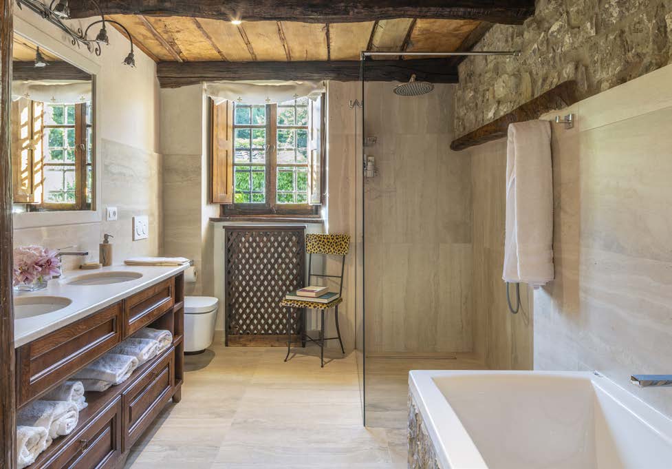 Bathroom with wooden ceiling beams, bathtub and a double vanity