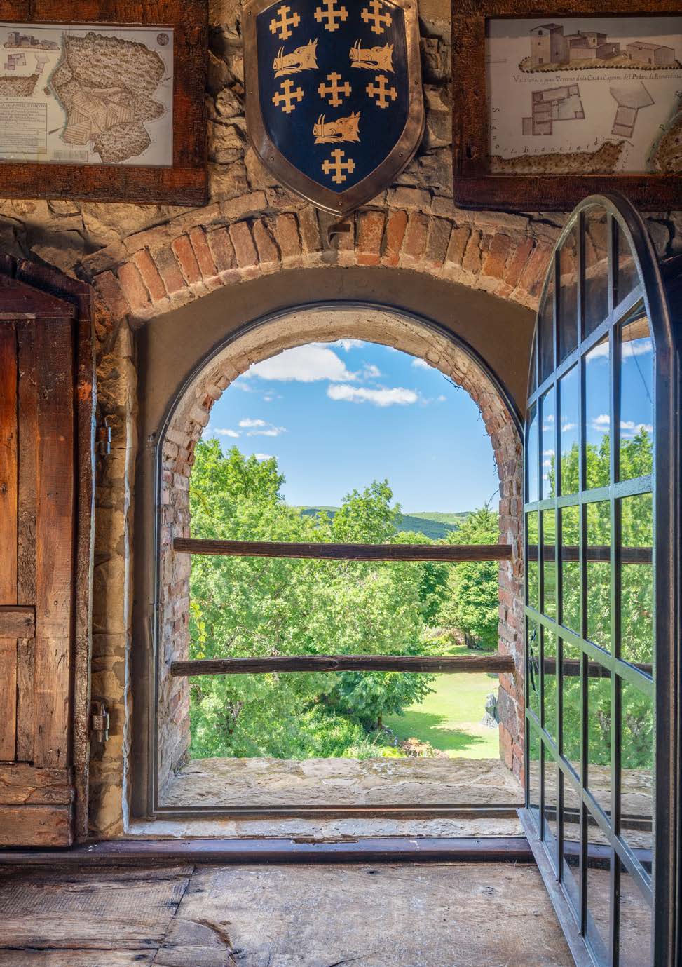 Stone room with arched window, wooden shutters and a coat of arms