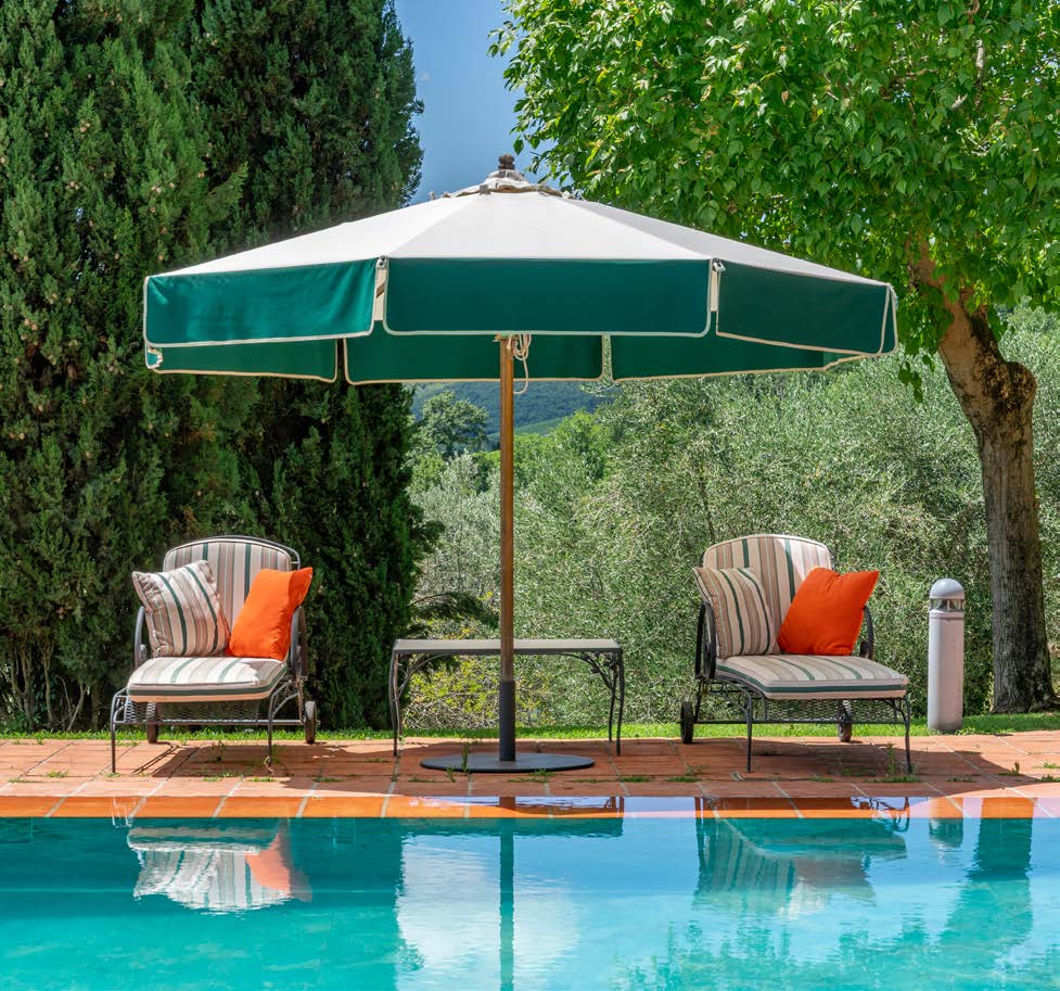 Poolside lounge chairs with green and white umbrella