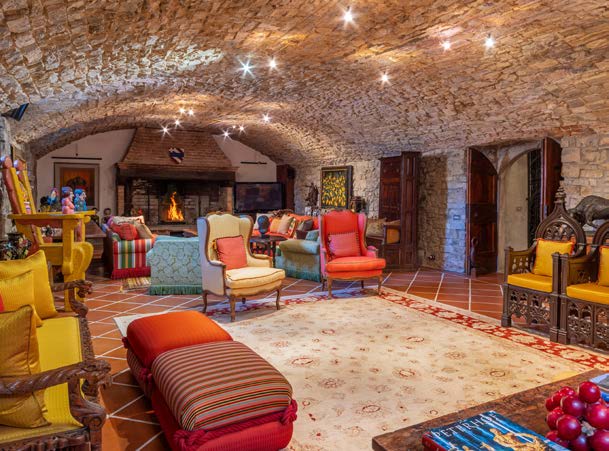 Cozy living room with stone arches, a fireplace and colourful seating