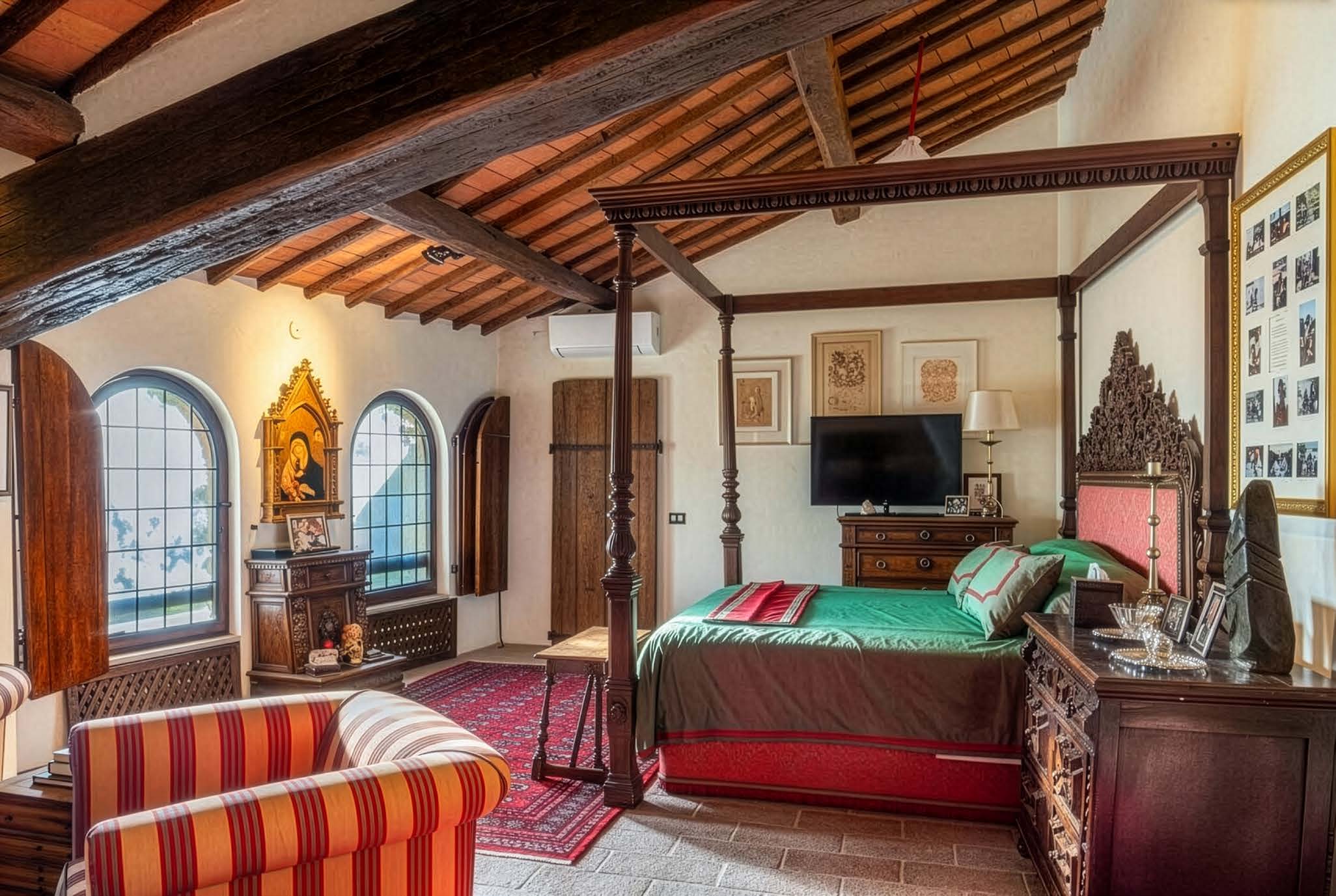 Bedroom with a four-poster bed, arched windows and wooden beams
